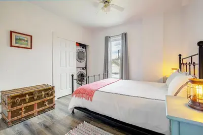 a bedroom with a bed and a washing machine at Stiles Historical Estate - 26th St in Denver