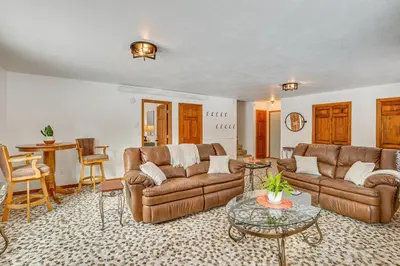a living room with leather couches and a table at Enjoy Deck and Mtn Views Grand Lake Retreat! in Grand Lake