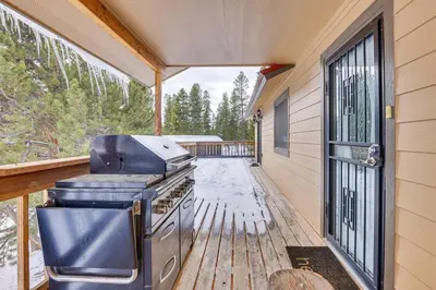 a screened in porch with a stove on a deck at Enjoy Deck and Mtn Views Grand Lake Retreat! in Grand Lake