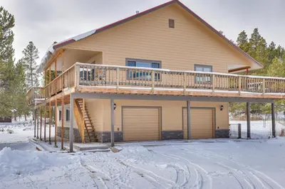 a house with a deck in the snow at Enjoy Deck and Mtn Views Grand Lake Retreat! in Grand Lake