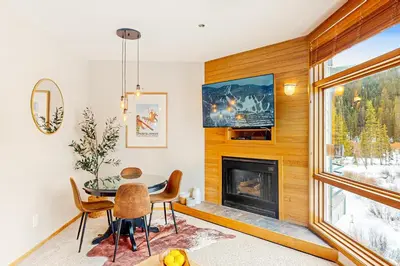 a dining room with a table and a fireplace at River Run Sanctuary in Keystone