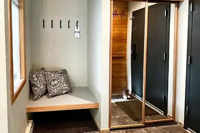 a hallway with a bench and a mirror and a door at River Run Sanctuary in Keystone