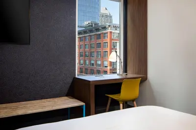 a room with a bed and a desk and a window at Aloft Denver Downtown in Denver