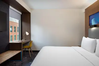 a hotel room with a bed and a desk at Aloft Denver Downtown in Denver