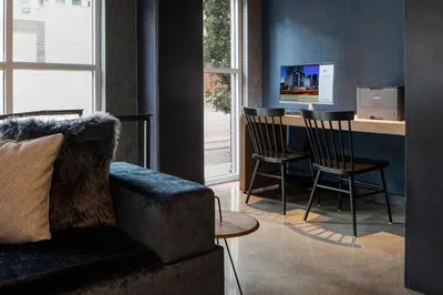 a living room with a couch and a table and chairs at Aloft Denver Downtown in Denver