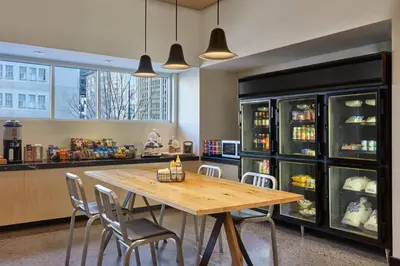 a dining room with a wooden table and chairs at Aloft Denver Downtown in Denver