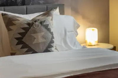a bed with pillows and a candle on a table at Colorado Haven: 5bd - Pool & Foosball - 10min UCB in Superior