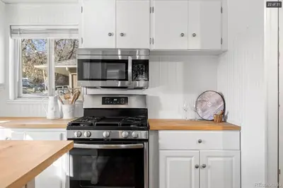 a kitchen with a stove and a microwave at Sunny Beach House of Olde Town Arvada in Arvada