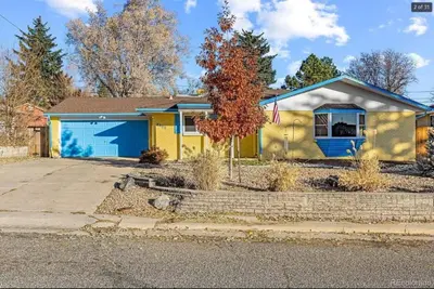 a yellow house with a blue garage at Sunny Beach House of Olde Town Arvada in Arvada