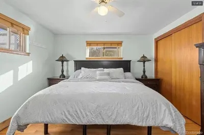 a bedroom with a large bed with a ceiling fan at Sunny Beach House of Olde Town Arvada in Arvada