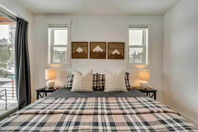 a bedroom with a bed and two windows at 2 Mi to RMNP Mtn-View Grand Lake Loft! in Grand Lake