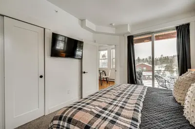 a bedroom with a bed and a window with a view at 2 Mi to RMNP Mtn-View Grand Lake Loft! in Grand Lake