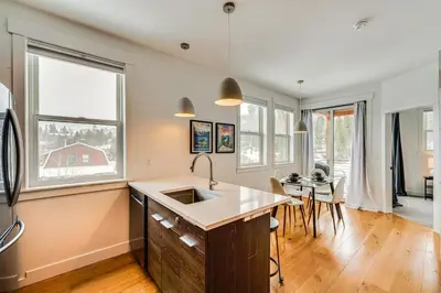 a kitchen with a sink and a table with chairs at 2 Mi to RMNP Mtn-View Grand Lake Loft! in Grand Lake