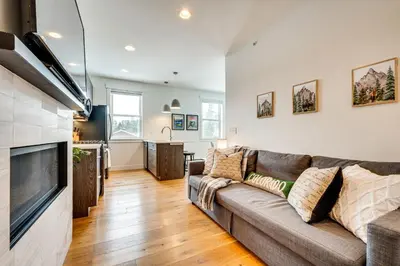 a living room with a couch and a kitchen at 2 Mi to RMNP Mtn-View Grand Lake Loft! in Grand Lake