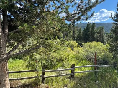 a wooden fence on a hill with a tree at Liftside 20B by SummitCove Lodging in Keystone