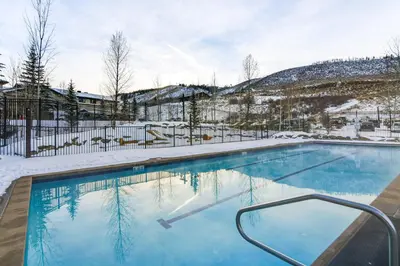 a swimming pool with snow on the ground at Ski-InandSki-Out Granby Ranch Condo with Pool Access in Granby