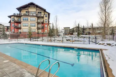 a swimming pool in front of a building at Ski-InandSki-Out Granby Ranch Condo with Pool Access in Granby