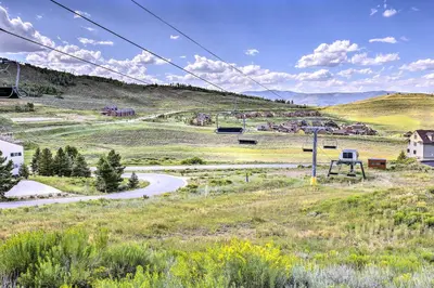 a road in the middle of a field with a hill at Ski-InandSki-Out Granby Ranch Condo with Pool Access in Granby