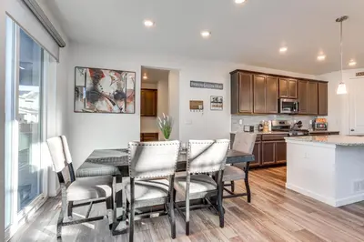 a kitchen and dining room with a table and chairs at 16 Mi to Denver Spacious Commerce City Home! in Commerce City