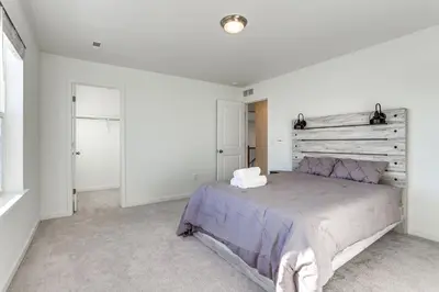 a bedroom with a large bed with a wooden headboard at 16 Mi to Denver Spacious Commerce City Home! in Commerce City