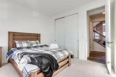 a bedroom with a large bed with a wooden headboard at 16 Mi to Denver Spacious Commerce City Home! in Commerce City