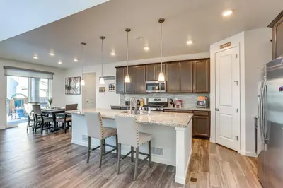 a kitchen with a large island with bar stools at 16 Mi to Denver Spacious Commerce City Home! in Commerce City