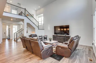 a living room with leather chairs and a tv at 16 Mi to Denver Spacious Commerce City Home! in Commerce City
