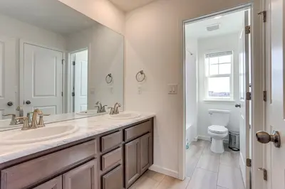 a bathroom with two sinks and a toilet at 16 Mi to Denver Spacious Commerce City Home! in Commerce City