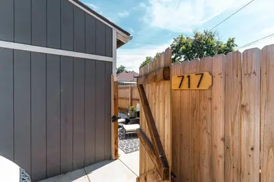 a wooden gate with a sign on it next to a fence at Beautiful Denver Carriage House in Denver