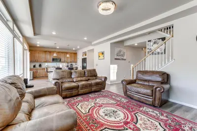 a living room with leather furniture and a kitchen at 17 Mi to Downtown Denver Modern Aurora Home! in Aurora