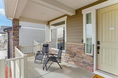 a porch of a home with two chairs and a door at 17 Mi to Downtown Denver Modern Aurora Home! in Aurora