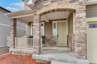 a house with an arched entryway with aige door at 17 Mi to Downtown Denver Modern Aurora Home! in Aurora