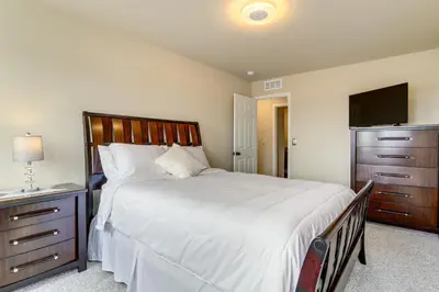 a bedroom with a large bed and a flat screen tv at 17 Mi to Downtown Denver Modern Aurora Home! in Aurora
