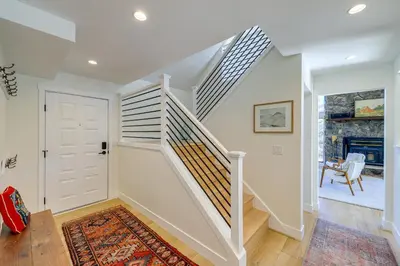 a white staircase in a home with a door at Spacious Black Hawk Home with Deck and Mountain Views! in Black Hawk
