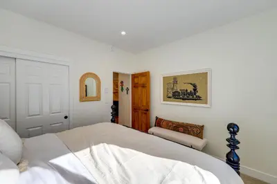a white bedroom with a bed and a chair at Spacious Black Hawk Home with Deck and Mountain Views! in Black Hawk