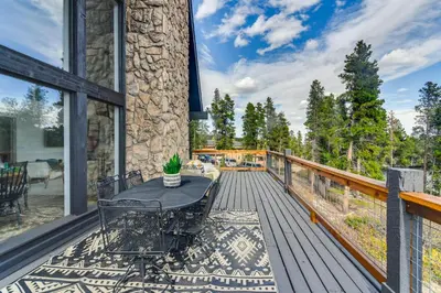 a patio with a table and chairs on a deck at Spacious Black Hawk Home with Deck and Mountain Views! in Black Hawk