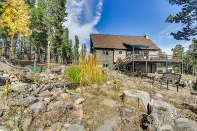 a home in the woods with a rock garden at Spacious Black Hawk Home with Deck and Mountain Views! in Black Hawk