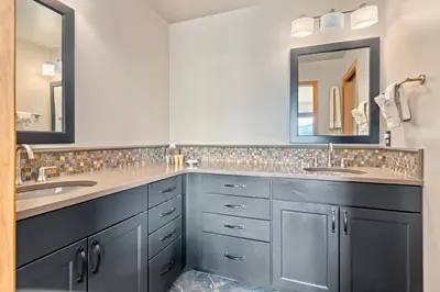 a bathroom with two sinks and two mirrors at Aspen Spirit Vacation Home at Windcliff home in Estes Park