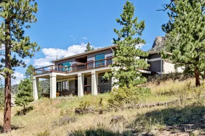 a house on top of a hill with trees at Aspen Spirit Vacation Home at Windcliff home in Estes Park