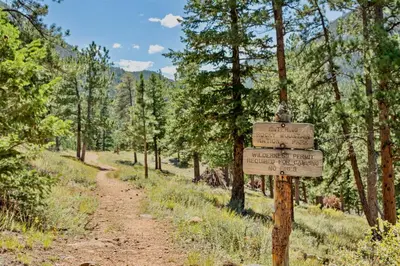 a sign on a dirt trail in a forest at Aspen Spirit Vacation Home at Windcliff home in Estes Park