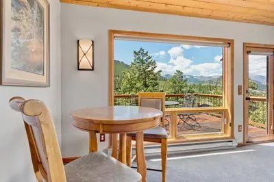 a table and chairs in a room with a window at Aspen Spirit Vacation Home at Windcliff home in Estes Park