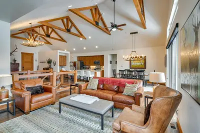 a living room with leather furniture and a kitchen at Family Home with Hot Tub 6 Mi to Winter Park Resort in Fraser