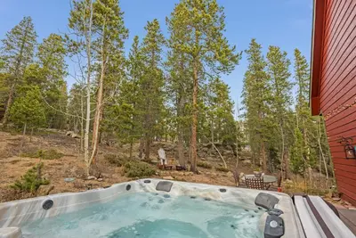 a hot tub in the backyard of a red house at Family & Dog Welcoming Lodge with Hot Tub & Games in Nederland