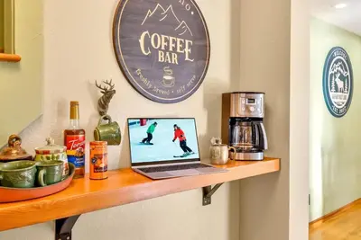 a laptop on a shelf with a coffee bar sign at Family & Dog Welcoming Lodge with Hot Tub & Games in Nederland