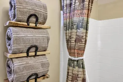 a stack of towels on a shelf in a bathroom at Family & Dog Welcoming Lodge with Hot Tub & Games in Nederland