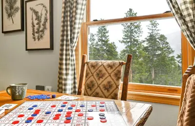a table with a chess board on it in front of a window at Family & Dog Welcoming Lodge with Hot Tub & Games in Nederland