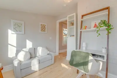 a living room with a white couch and a chair at Hot Tub, Fire Pits Ideally Located Denver Home! in Denver