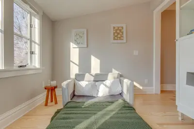 a white living room with a chair and a window at Hot Tub, Fire Pits Ideally Located Denver Home! in Denver