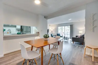 a dining room and living room with a table and chairs at Cozy Westminster Condo 14 Mi to Downtown Denver! in Westminster