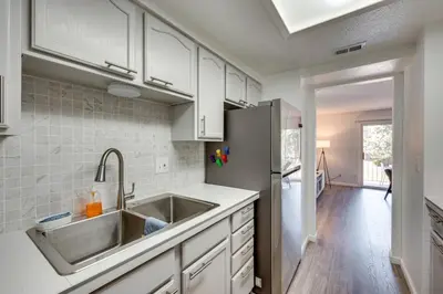 a kitchen with a sink and a refrigerator at Cozy Westminster Condo 14 Mi to Downtown Denver! in Westminster